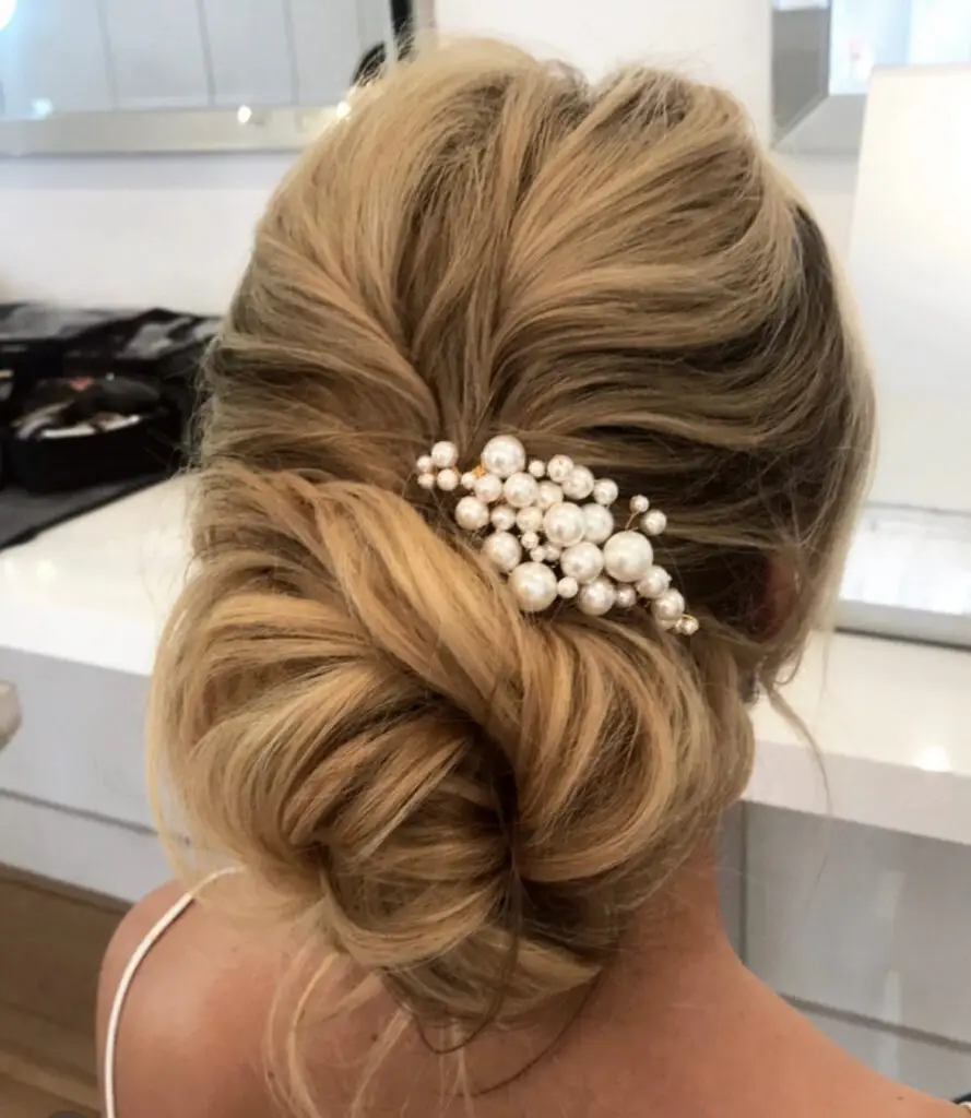 Low bridal chignon with pearl hair accessory